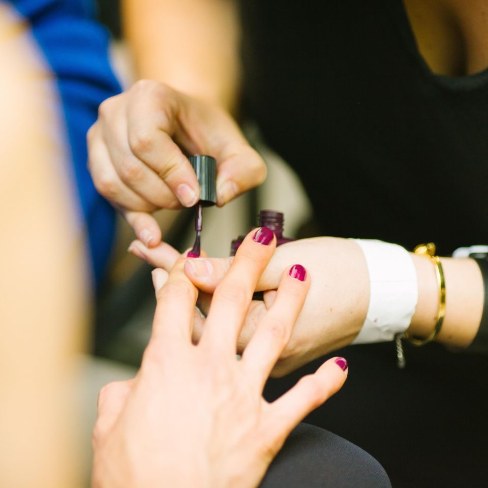 A nail technician applying polish to a client's nails