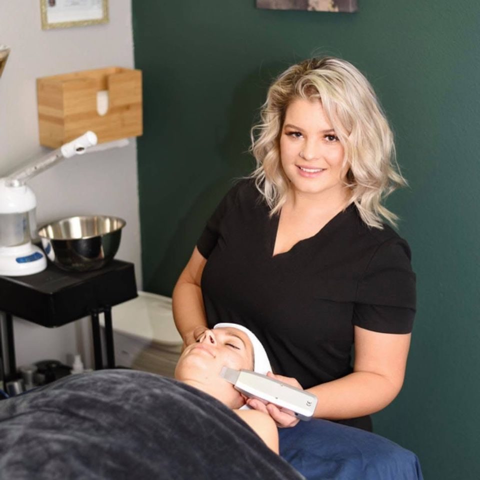 An esthetician performing a facial treatment